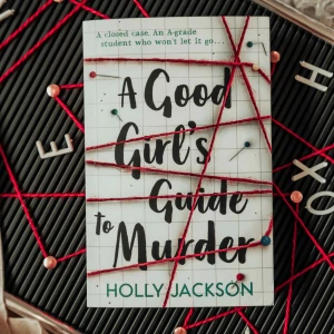 A Good Girl's Guide to Murder - En spännande deckare om en A-elev som inte kan släppa ett gammalt fall. Perfekt för dig som älskar mysterier och intriger. Boken är omslagen med ett rutnät och dekorerad med röda trådar och nålar, vilket ger en känsla av en utredningstavla.