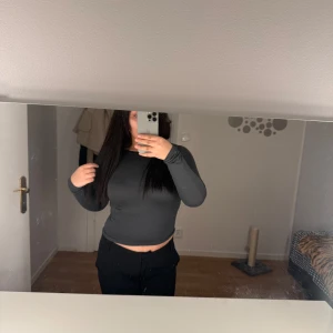 Mörkgrå långärmad tröja - Säljer en helt ny mörkgrå långärmad tröja med en tight passform. Perfekt för en enkel och bekväm look. Tröjan är gjord i ett mjukt material som känns skönt mot huden.