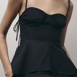 Svart topp - Snygg svart topp med smala axelband. Toppen har en åtsittande passform med knytband i sidorna!! 💕