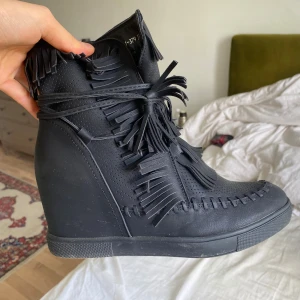 Svarta boots med fransar - Snygga svarta boots med kilklack och fransdetaljer. Nytt skick 