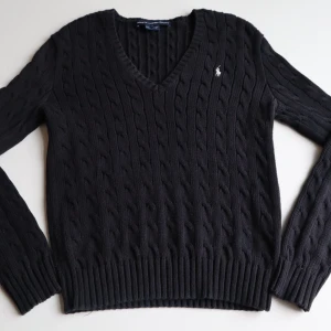  tröja från Ralph Lauren - svart stickad tröja från Ralph Lauren med v-ringning och kabelstickat mönster. Tröjan har långa ärmar och en liten broderad logga på bröstet. Perfekt för en stilren look. Den har aldrig blivit använd så sälj väldigt rabatterad orginal pris 2 889kr säljer billigare 