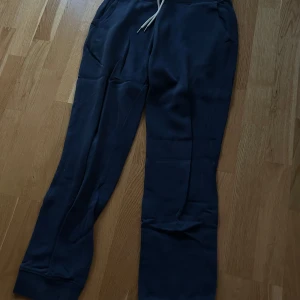 Mörkblå mjukisbyxor från The Essentials - Säljer ett par mörkblå mjukisbyxor från Race Marine, The Essentials. Byxorna har en bekväm passform med snörning i midjan och ribbade muddar vid bensluten.