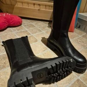 Svarta stövlar med grov sula - Snygga svarta stövlar med grov sula och hög skaft. Märket Angulus stövletter, svart skinn,  stl 38 (passar slt37) mkt fin skick ny pris 1795. Mitt pris 400 Perfekta för höst- och vinterväder. De har en rund tå och är tillverkade i skinn