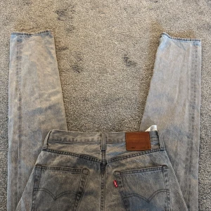 Grå Levis 501 jeans - Säljer ett par klassiska grå Levis 501 jeans. De har en rak passform och är tillverkade i denim. Mycket bra skick!!!!!
