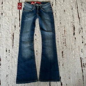 Dallas bootcut jeans - Jättefina jeans från märket Dallas Jeans som är helt nya med prislappen kvar. Tyvärr saknas knapp där fram men annars är skicket som nytt. Snygg blå färg som är något ljusare i verkligheten med fin bootcut och låg midja. Skriv gärna om ni har frågor!
