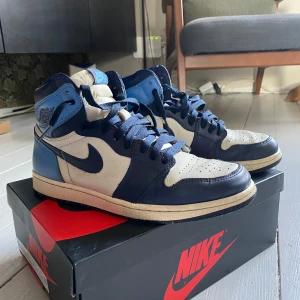 Nike Air Jordan 1 Retro High - Säljer ett par Nike Air Jordan 1 Retro High i en snygg kombination av blått och vitt. Köpte hos 2amclub! Kvittot finns kvar, lådan följer med!