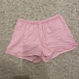 Rosa shorts från H&M - Säljer ett par bekväma rosa scandi shorts från H&M. De är tillverkade i 100% bomull och har en elastisk midja för extra komfort. Perfekta för en avslappnad dag hemma eller ute i solen.