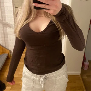 Brun långärmad topp - Säljer en brun långärmad topp med v-ringning. Perfekt för en avslappnad stil. Passar bra till både jeans och mjukisbyxor.