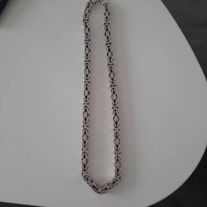 Kejsarlänk 925 - Halsbandet har en robust och stilren look, perfekt för att ge en extra touch till din outfit. Märkt med 925, vilket indikerar att det är tillverkat av sterlingsilver. Halsbandet är 70 cm långt och är 10mm bred, väger strax över 370 gram. För bådas säkerhet sköts försäljning enbart i person