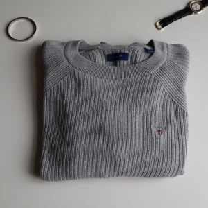  Gant cardigan  - Säljer en  grå stickad cardigan från Gant. Tröjan har en diskret broderad logga på bröstet och är tillverkad i ett mjukt och stretchigt material, original pris 1389 säljer för 389
