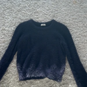 Mörkblå fluffig tröja från JDY - Säljer en supermjuk och fluffig mörkblå tröja från JDY. Perfekt för kyliga dagar med sin mysiga känsla. Tröjan har långa ärmar och en rund halsringning. Ett måste för garderoben!
