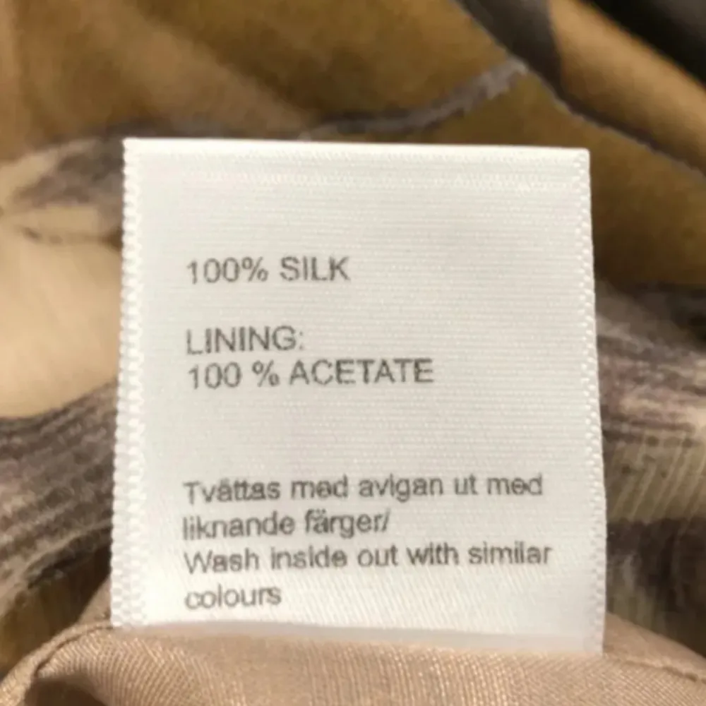 Säljer en elegant blommig klänning från Prêt i 100% silke. Klänningen har korta ärmar och ett vackert blommönster i beige och grå toner. Perfekt för en stilfull look.. Mekot.