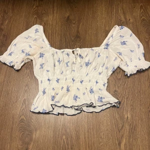 Blommig blus från H&M - Super söt blommig topp från H&M! Med resår i midjan och puffärmar.
