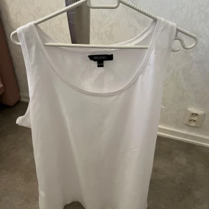Vit linnetopp från Cellbes - Enkel och stilren vit linnetopp från Cellbes. Toppen är ärmlös med rund halsringning och har en rak passform. Perfekt att matcha med jeans eller kjol för en clean look.