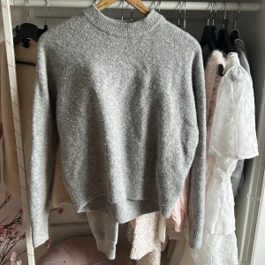 Grå stickad tröja från H&M - Mysig grå stickad tröja från H&M i storlek S. Tröjan har en klassisk rund halsringning och är långärmad. Den är tillverkad i ett mjukt och fluffigt material som passar perfekt för kyliga dagar. Enkel och stilren design som är lätt att matcha med olika outfits. Den är lite nopprig som man kan se i den andra bilden då den är köpt av annan ägare från Plick. Därav priset.❤️