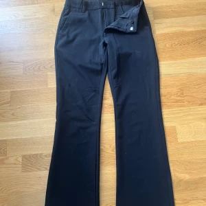 Svarta kostymbyxor  - Svarta kostymbyxor från Lindex i klassisk modell med raka ben och lätt utsvängd bootcut. Den är från Lindex och säljer dem då fem blivit för korta i benen (161cm) använda 3 gånger