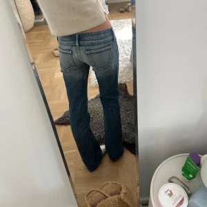 Diesel jeans - Säljer ett par snygga lågmidjade blå jeans med bootcut passform. Jeansen har slitna detaljer, stora framfickor och dubbla knappar i midjan. Perfekta för dig som gillar en avslappnad men trendig look.
