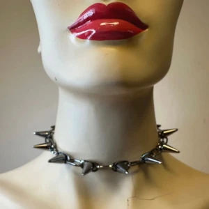 Spikchoker i metall – punkig statementaccessoar - Ny & oanvänd  - Grym choker i silvrig metall med kraftiga spikes – perfekt för dig som gillar punk, goth eller alternativ stil. Justerbar längd med karbinhake och förlängningskedja. Snygg kontrast till både enkel klänning och band-tisha. Ingen prutning – priset är redan lågt, men jag erbjuder rabatt vid köp av flera saker. Jag rensar smyckesskrin och garderob, så spana gärna in mina andra annonser också!  ⸻  