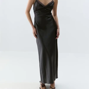 Svart långklänning från Gina Tricot - Supersnygg svart långklänning från Gina Tricot i satin. Klänningen har smala axelband, spetsdetaljer vid bysten och en figurnära passform. Perfekt för dig som vill ha en elegant och stilren look. Den är jätteskön att ha på!🖤Den är använd minst 2 gånger och köpte den för 600kr. Pris går alltid att diskuteras