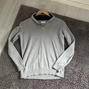 Grå half zip tröja från MNG - Snygg grå långärmad tröja från MNG med half zip-dragkedja vid halsen och ribbade muddar. Tröjan har en svart ribbad detalj på insidan av kragen och är i mjukt material som passar perfekt till lager-på-lager-stil. Väldigt soft och allmänt skön köptes för 599kr. 145-160 cm. Inte använd så mycket mest legat i garderoben. pris kan diskuteras vid snabb affär