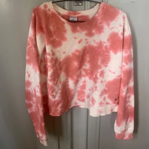 Rosa tie-dye sweatshirt från Stories - Säljer en oversized sweatshirt från Stories i storlek L. Tröjan har ett snyggt rosa och vitt tie-dye mönster, rund halsringning och långa ärmar. Passar även storlek s-m.