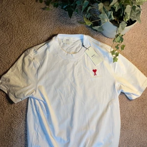Vit AMI t-shirt  - Fet AMI t-shirt i storlek M. Passar perfekt nu till sommaren. Tröjan är i nyskick med prislapp