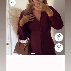 Vinröd kofta med v-ringning och knappar - Snygg vinröd kofta med v-ringad hals och knappar framtill. Modellen är figurnära med långa ärmar och stilren look. Perfekt att styla med jeans eller kjol för en trendig vibe.