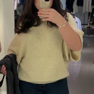 Beige tröja från Zara  - Mysig beige tröja  med lös passform och breda ärmar. Tröjan är stickad i en mjuk ullmix och har en hög, ribbad krage som ger extra värme. Perfekt för lager-på-lager och chill höst- och vinterstil.