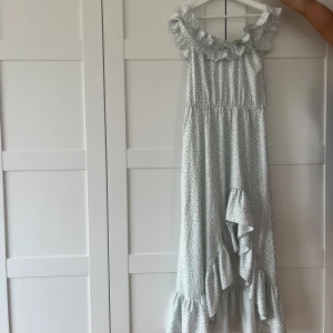  långklänning med volanger och slit  - Superfin ljusblå långklänning med en slit och volangdetaljer i storlek S. Klänningen är från VILA