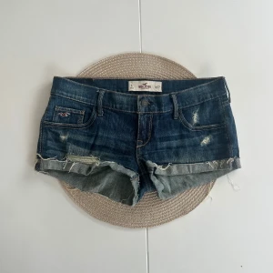 Lågmidjade jeansshorts Hollister  - Ett par Hollister jeansshorts i storlek W27 (S). Rakt över midjemått: 38cm. Längd: 18cm. Gren: 17cm. D10
