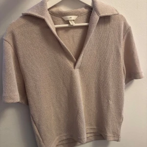 Beige stickad pikétröja från H&M -  en beige stickad pikétröja från H&M med korta ärmar och öppen krage. 