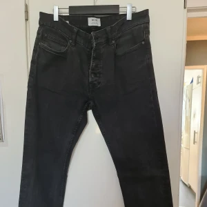 Svarta jeans från Only & Sons W31 L32 - Svarta jeans från Only & Sons i klassisk femficksmodell. Jeansen har en smal passform och är tillverkade i bomull med lite stretch för extra komfort. Snyggt tvättade med en något sliten look, perfekta till sneakers eller boots.