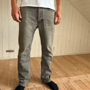 Grå jeans från Acne Studios Blå Konst - Snygga gråa jeans från Acne Studios! Jeansen har rak passform och normal midja. Materialet är robust denim i en snygg tvättad grå nyans. Jeansen har ett hål som går att sy igen! Därmed pris eller bud! 