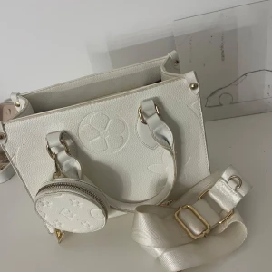 Vit väska med guldiga detaljer  - Jätte fin väska från Spanien köpt för 50 £ den kommer med axelband 