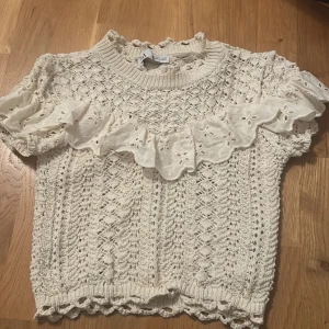 Vit stickad topp med volang från Zara - Superfin vit stickad topp från Zara med korta ärmar och broderad volangdetalj över bröstet. Sött hålmönster och ribbad halsringning med volangkant. Sån fin nu till sommaren och perfect för dig som gillar stickat, fast somrigt 💕💕😍😍😍