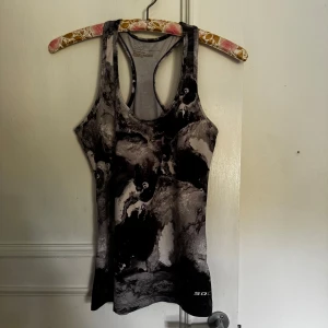 Svartgrå linnetopp från SOC - Säljer en sportig linnetopp från SOC i svart och grått med coolt marmorerat mönster. Modellen är ärmlös med brottarrygg, perfekt för träning eller gym. Kan mötas i Norrköping 😊