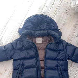 moncler jacka - en bra moncler jacka den är lite sönder inuti som ni ser på sista bilden men det är inget man märker, den är mörkblå och brun inuti
