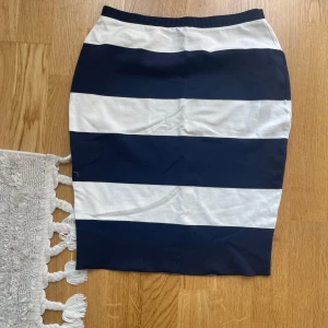 Randig kjol från Holly & Whyte - Snygg pennkjol från Holly & Whyte med breda marinblå och vita ränder. Kjolen har resår i midjan och är tillverkad i mjuk bomull, perfekt för en chill och stilren look.