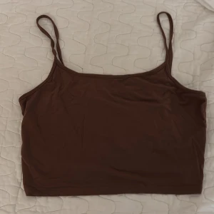Brun linnetopp med smala axelband - Säljer en brun linnetopp med smala axelband och croppad passform från shein 