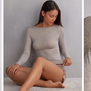 Ljusgrå långärmad topp i bomull - Superskön och figurnära långärmad topp i l beige. Tunn och stretchig bomullsmix med rund halsringning och smala ärmar. Perfekt att styla med jeans eller shorts för en clean och enkel look. Skön att ha på sig den på sommaren då den är tunn.