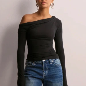 Svart offshoulder långärmad topp - Snygg svart topp med offshoulder-design och långa ärmar. Endast använd 1 gång så skicket är som ny.