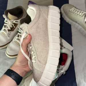 Beiga sneakers från Eytys i linne/canvas - Säljer ett par stilrena sneakers från Eytys i beige linne canvas med chunky vit sula och klassisk snörning. Skorna har en lila detalj på hälen och Eytys-logga på plösen och innersulan. Perfekta för dig som gillar minimalistisk och modern stil. Storlek 44 (US10/WMNS11,5) låda saknas och hälarna är slitna som syns på bilderna. Annars är dom i helt magiskt skick helt utan hål eller så!