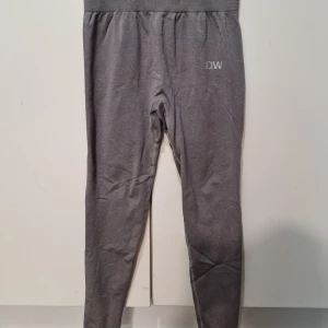 Grå leggings från ICANIWILL - Snygga grå leggings från ICANIWILL med hög midja och tight passform. Perfekta för träning eller chill, tillverkade i mjukt och stretchigt material som sitter skönt hela dagen. Diskret logga på höften för en clean look.