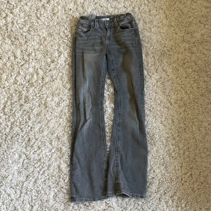 Grå bootcut jeans från Gina Tricot - Snygga grå jeans från Gina Tricot i bootcut-modell. Jeansen har klassiska fickor fram och bak med coola detaljer och silvriga knappar. Jätte bra skick.  Tillverkade i mjukt denimtyg som sitter skönt och passar perfekt till en avslappnad stil. Orginalpris 400kr. Pris kan diskuteras 