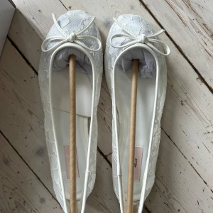 Vita spetsa ballerinaskor från Nelly - Snygga vita ballerinaskor från Nelly med spets. Helt nya, bara testade. I orginal förpackning! Säljes då det är för stora! Originalpris 349kr. Storlek 38 men skulle säga mer 39/40!