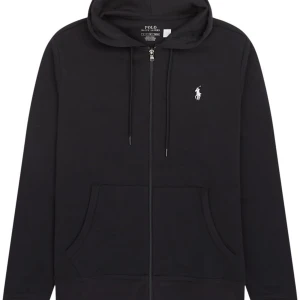 Svart hoodie från Polo Ralph Lauren - Svart hoodie från Polo Ralph Lauren med vit broderad logga på bröstet. Tröjan har dragkedja, huva med snörning och stora fickor framtill. Tillverkad i mjuk bomull, perfekt för en chill och stilren look.