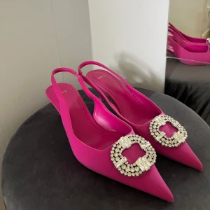 Rosa pumps  - Snygga pumps i stark rosa  med spetsig tå och låg klack. 