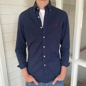 Polo Ralph lauren skjorta - Säljer denna riktigt snygga Ralph lauren skjorta den är i mycket bra skick enda defekten är att tvättlappen är avklippt, storlek S och modell slim fit den är 75 cm lång och 45 cm bred under armhålorna, hör gärna av dig vid frågor!