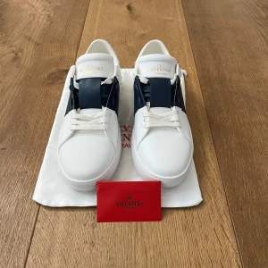 Valentino Garavani Open sneakers vit/blå - Säljer dessa snygga Valentino Open för bra pris. Inga defekter, använt ett fåtal gånger. Är väldigt öppen för byten av andra skor. Hör av dig ifall du har frågor eller behöver fler bilder. Pris kan diskuteras vid snabbaffär!!!