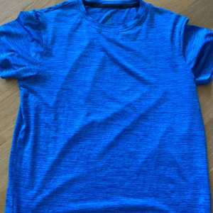 Blå mellerad tränings t-shirt från SOC - Sportig blå t-shirt från SOC i funktionsmaterial med diskret randigt mönster. Perfekt för träning eller när du vill ha en lätt och luftig tee. Klassisk rund halsringning och korta ärmar. 